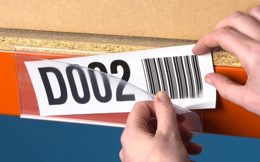 Barcode location label being fitted to shelving